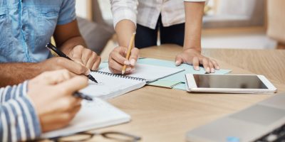 gros-plan-travail-equipe-o-nouveau-projet-dans-espace-coworking-redaction-idees-recherche-graphiques-tablette-ordinateur-portable-travail-equipe-concept-entreprise-min